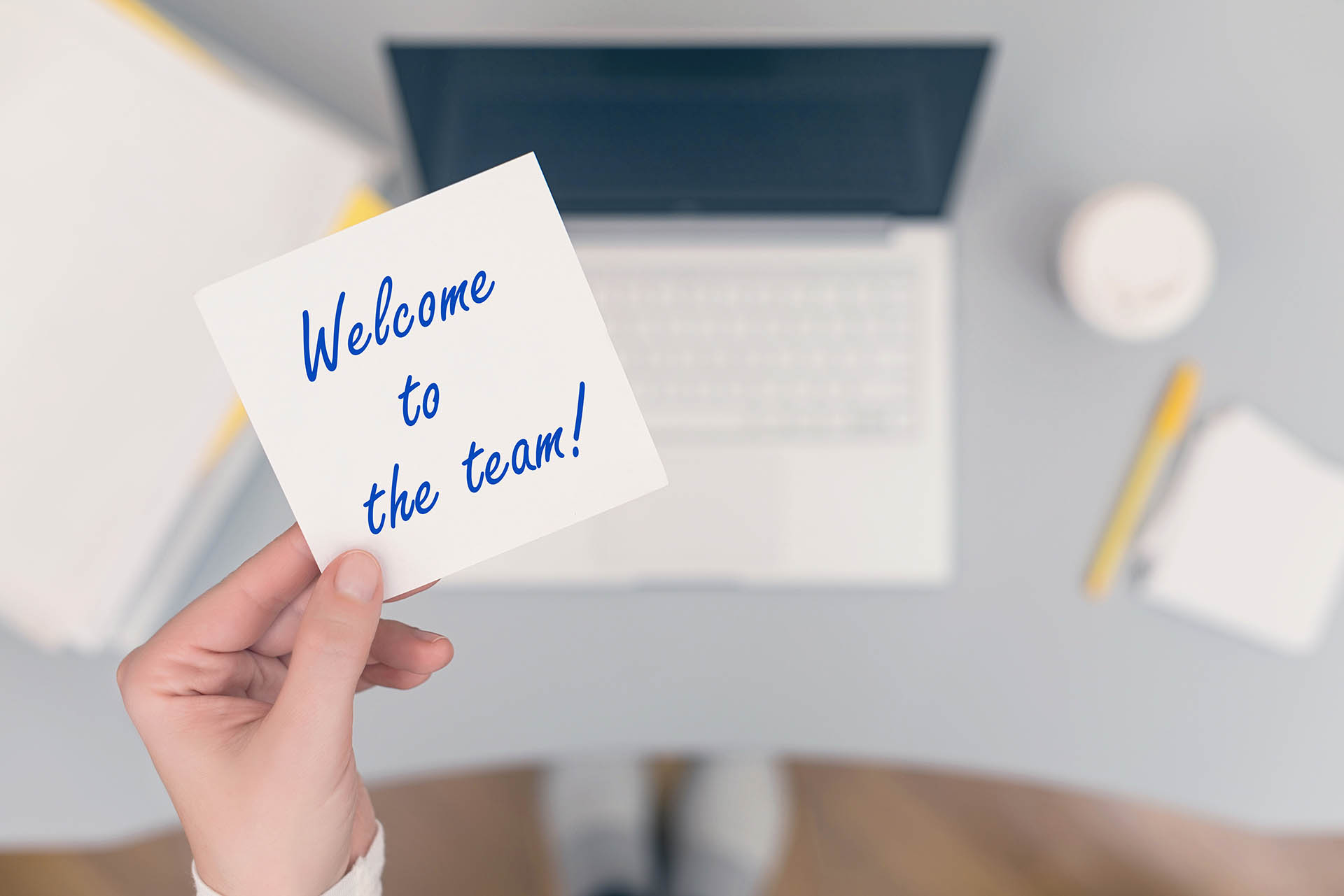 Woman,clerk,sitting,holding,note,paper,sticker,with,welcome,to